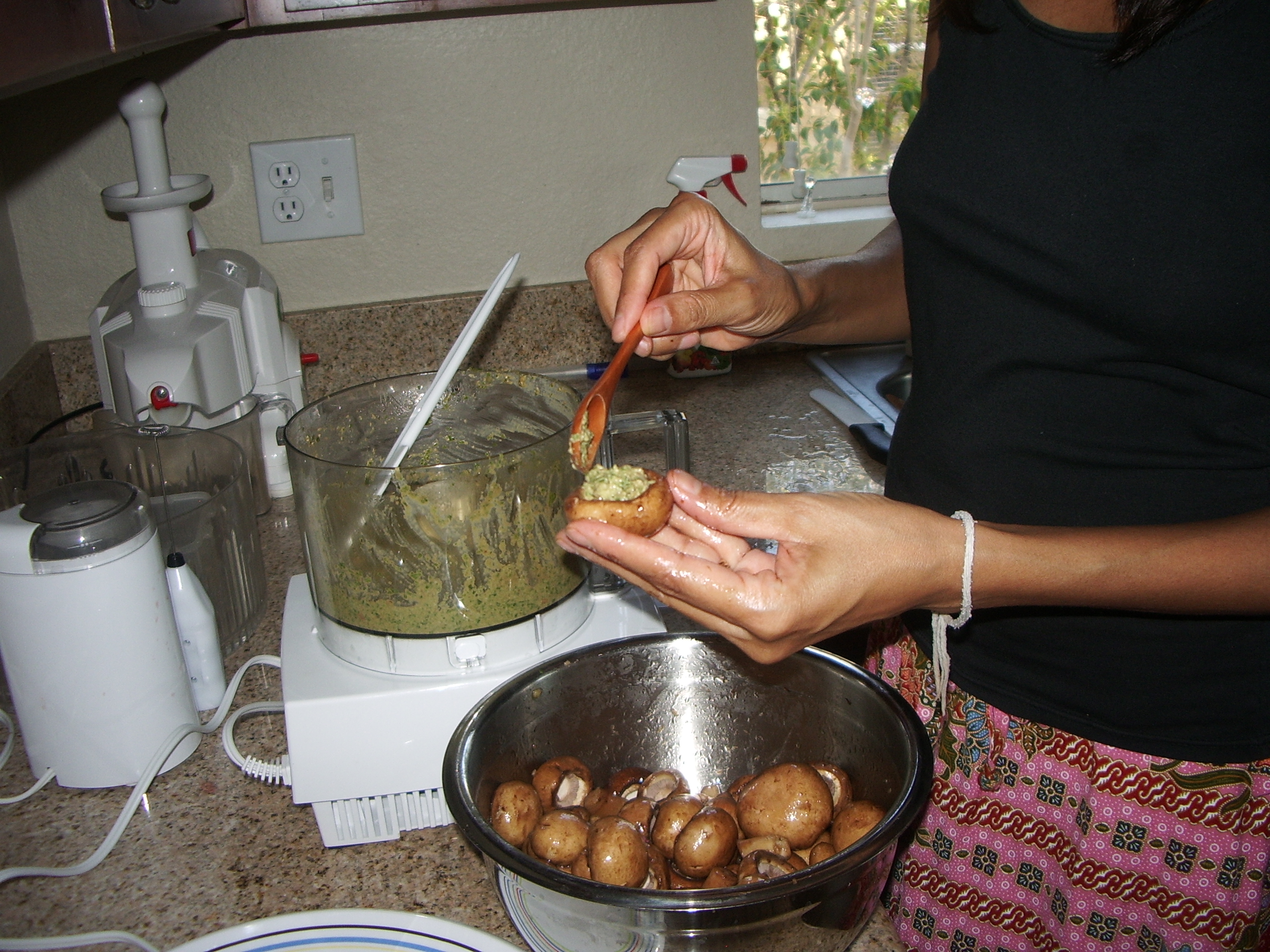 Stuffing the mushrooms with pesto sauce